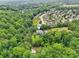 Aerial shot showcases this home nestled within a lush, green neighborhood with mature trees and a nearby pond at 4685 Braselton Hwy, Hoschton, GA 30548