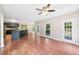 Open-concept living room featuring hardwood floors, a ceiling fan, and access to the back patio at 4685 Braselton Hwy, Hoschton, GA 30548