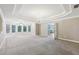Large main bedroom with a tray ceiling, fan, and sitting area with large windows at 4685 Braselton Hwy, Hoschton, GA 30548