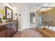 Bathroom featuring tile flooring, soaking tub with shower and double sink vanity at 1605 Spinnaker Drive, Alpharetta, GA 30005