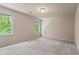 Spacious bedroom with carpet floors, neutral walls, and natural light from two windows overlooking the backyard at 1605 Spinnaker Drive, Alpharetta, GA 30005