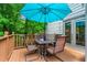 View of outdoor deck with lush landscaping, table and chairs, and umbrella at 1605 Spinnaker Drive, Alpharetta, GA 30005