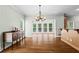 Open dining room with hardwood floors, chandelier, butler's pantry, and large windows offering views of the outdoors at 1605 Spinnaker Drive, Alpharetta, GA 30005