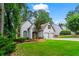 Beautiful gray shingle home with a well-manicured lawn, mature trees, brick chimney, and two-car attached garage at 1605 Spinnaker Drive, Alpharetta, GA 30005