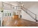 Open-concept living room featuring hardwood floors, soaring ceilings, staircase, and dining area with a bar counter at 1605 Spinnaker Drive, Alpharetta, GA 30005