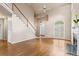Spacious living room with hardwood floors, fireplace, arched window, and staircase leading to the upper level at 1605 Spinnaker Drive, Alpharetta, GA 30005