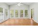 Bright sunroom with hardwood floors, ceiling fan, and large windows offering views of the surrounding landscape at 1605 Spinnaker Drive, Alpharetta, GA 30005