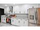 Modern kitchen featuring white cabinets, granite countertops, stainless appliances, and herringbone backsplash at 5077 Martindale Ln, Stone Mountain, GA 30088