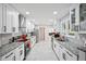 Galley kitchen featuring white cabinets, granite countertops, stainless appliances, and herringbone backsplash at 5077 Martindale Ln, Stone Mountain, GA 30088