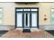 Front door to apartment with black frame, glass panes, curtains, and brick walkway at 5300 Peachtree Rd # 1608, Chamblee, GA 30341