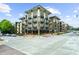 Attractive 4-story apartment building with black awnings over storefronts, black balconies, and green-tan facade at 5300 Peachtree Rd # 1608, Chamblee, GA 30341