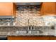 Close-up of a kitchen featuring dark granite countertops, tile backsplash, and wood cabinets at 5300 Peachtree Rd # 1608, Chamblee, GA 30341