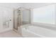 Bright bathroom showcases a luxurious soaking tub with jets and separate shower behind glass enclosure at 1122 Cayuga Ct, Dacula, GA 30019