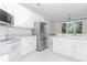 Well-lit kitchen featuring stainless steel appliances, white cabinetry, and laminate countertops at 1122 Cayuga Ct, Dacula, GA 30019
