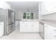 Bright and clean kitchen featuring all-white cabinets and stainless steel appliances at 1122 Cayuga Ct, Dacula, GA 30019