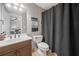 Bathroom showcasing neutral tiling, wood vanity, and a shower with black curtain at 3438 Winborn Walk Northwest Nw, Kennesaw, GA 30152