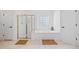 Bathroom features a tub, a separate shower, neutral tiling, and natural light at 3438 Winborn Walk Northwest Nw, Kennesaw, GA 30152
