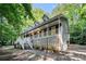 Two story home with inviting covered front porch and white wooden railings, nestled among mature trees at 1488 White Columns Blvd, Canton, GA 30115
