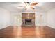 Open-concept living room with a cozy stone fireplace, hardwood floors, and French doors at 1488 White Columns Blvd, Canton, GA 30115