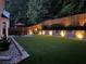 Backyard features a green lawn, fence, patio, and manicured landscaping with lighting at 181 Weatherstone Dr, Woodstock, GA 30188