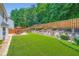 Backyard features a green lawn, fence, patio, and manicured landscaping at 181 Weatherstone Dr, Woodstock, GA 30188
