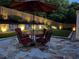 Relaxing outdoor stone patio features an umbrella, table, and four chairs at 181 Weatherstone Dr, Woodstock, GA 30188