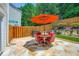 Relaxing outdoor stone patio features an umbrella, table, and four chairs at 181 Weatherstone Dr, Woodstock, GA 30188