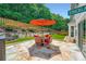 Relaxing outdoor stone patio features an umbrella, table, and four chairs at 181 Weatherstone Dr, Woodstock, GA 30188
