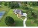Stunning aerial view of a large house with a tennis court, lush green lawn, driveway, and pond in the background at 5690 Rutland Trce, Lithonia, GA 30058