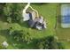 Overhead view of a house with a tennis court, surrounded by green lawns and trees showcasing its estate-like setting at 5690 Rutland Trce, Lithonia, GA 30058