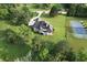 Aerial view showing the house and the backyard featuring a tennis court and plenty of green space with tall trees at 5690 Rutland Trce, Lithonia, GA 30058