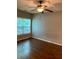 Bedroom with hardwood floors, a ceiling fan, and a bright window view at 1428 Orchard Park Dr, Stone Mountain, GA 30083