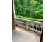 Covered back porch with white railing overlooking a lush backyard at 1428 Orchard Park Dr, Stone Mountain, GA 30083