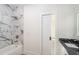 Modern bathroom with marble tiled shower and tub featuring gold fixtures and a sliding door entry at 2312 Herring Sw Rd, Atlanta, GA 30311