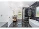 Modern bathroom features sleek black marble tile, dual vanities, soaking tub, and glass shower at 2312 Herring Sw Rd, Atlanta, GA 30311