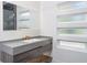 Bathroom vanity features grey stone counters, wood cabinetry, and a modern mirror with great lighting at 2312 Herring Sw Rd, Atlanta, GA 30311