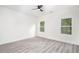 A spacious bedroom with wood-look floors, white trim and natural light from a pair of windows at 2312 Herring Sw Rd, Atlanta, GA 30311