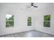 Bright bedroom with light gray flooring, white walls and three large windows at 2312 Herring Sw Rd, Atlanta, GA 30311