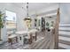 Open-concept living and dining area with hardwood floors, modern decor, and large windows at 2312 Herring Sw Rd, Atlanta, GA 30311