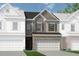New construction townhome featuring a brick and siding exterior with attached two-car garage at 18 Jacobs Farm Ln # 9, Lawrenceville, GA 30045