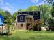 Two-story home with backyard featuring green grass, a wood staircase to a deck, and vibrant blue siding at 2625 Semmes St, Atlanta, GA 30344