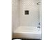 Bathroom featuring a tub with white subway tile surround and contrasting dark grout and dark floor at 2625 Semmes St, Atlanta, GA 30344