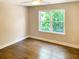 Bright bedroom features hardwood floors, a ceiling fan, and a window overlooking the lush greenery at 2625 Semmes St, Atlanta, GA 30344