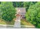 An aerial view of a charming home with a landscaped yard nestled among lush trees at 4092 Duran Ln, Auburn, GA 30011