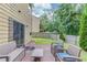 Backyard with a patio, seating, a well-kept lawn, and mature trees that create a tranquil outdoor retreat at 4092 Duran Ln, Auburn, GA 30011
