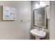 Powder room featuring a pedestal sink, decorative mirror, and accent wall art at 4092 Duran Ln, Auburn, GA 30011