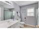 Well-lit bathroom with a large mirror, ceramic tile, and neutral tones provides a clean and functional space at 4092 Duran Ln, Auburn, GA 30011