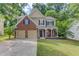 Charming two-story home features a brick and tan exterior, a well-manicured lawn, and a two-car garage at 4092 Duran Ln, Auburn, GA 30011