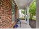 Inviting front porch featuring brick accents, white columns, and a cozy bench with decorative pillows at 4092 Duran Ln, Auburn, GA 30011
