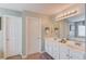 Bright main bathroom featuring double sinks, vanity, and private toilet area at 4092 Duran Ln, Auburn, GA 30011